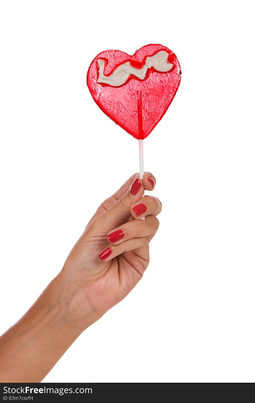 Heart shape lollipop in a hand isolated over white background