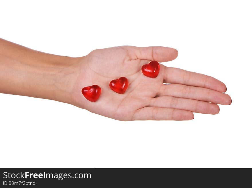 Heart shape candies in a hand isolated over white background