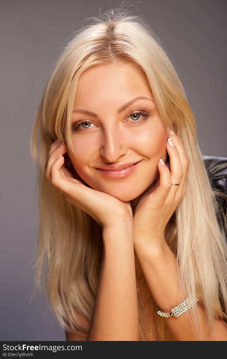 Young woman with beautiful blonde hair on a gray background. Young woman with beautiful blonde hair on a gray background