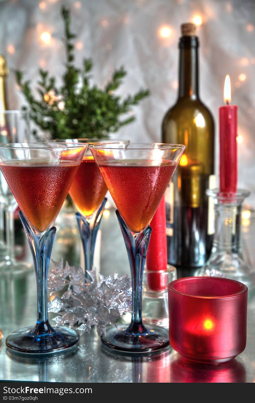 Red wine in glasses,red candle,bottles on silver backgroun with blurred lights. Red wine in glasses,red candle,bottles on silver backgroun with blurred lights.