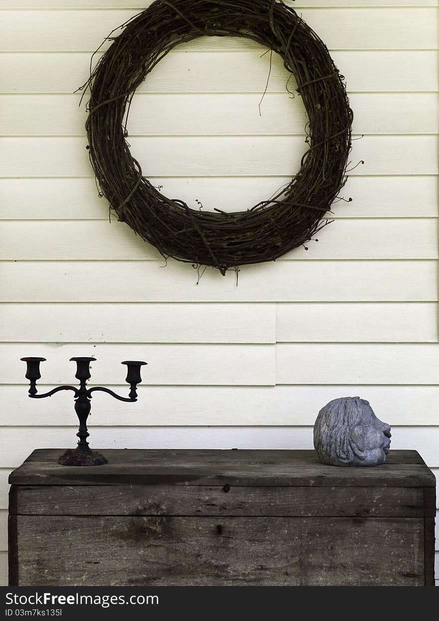 An arrangement of decorative ornaments on a patio with a wreath, chest and ornaments. An arrangement of decorative ornaments on a patio with a wreath, chest and ornaments.