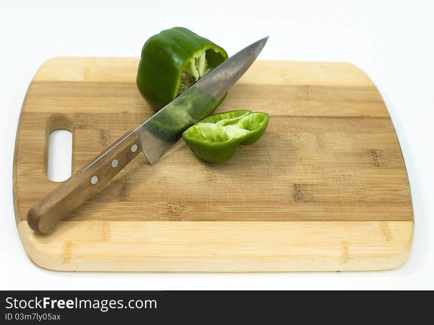 Green pepper cut with a knife on the white background. Green pepper cut with a knife on the white background