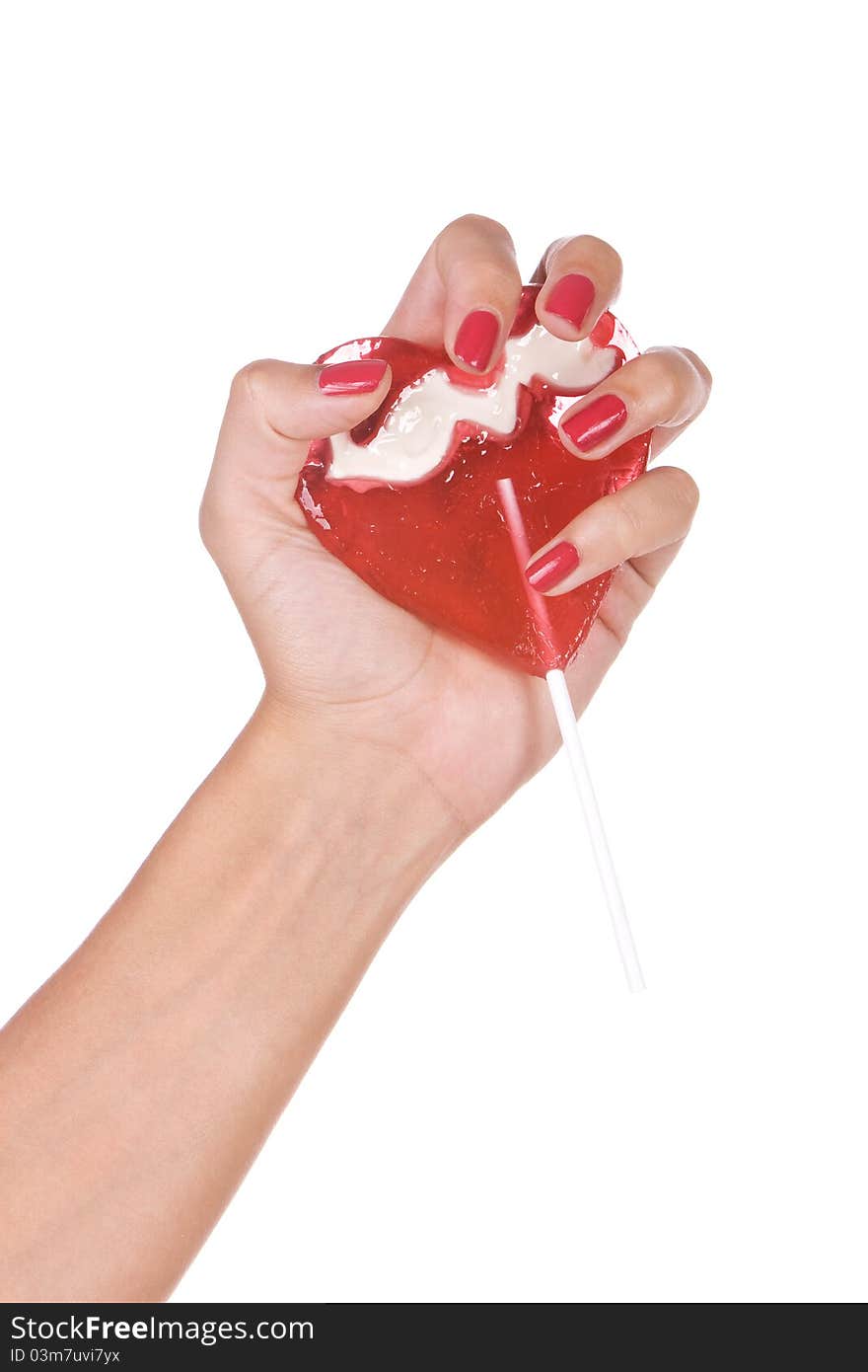 Heart shape lollipop in a hand isolated over white background