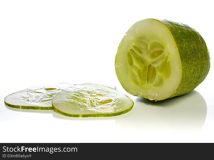 Cucumber and thin cucumber slices against a white background. Cucumber and thin cucumber slices against a white background