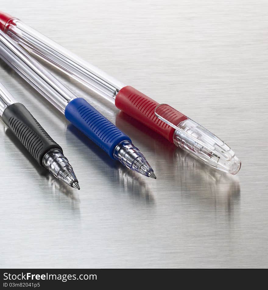 Pens, red, blue and black on stainless steel