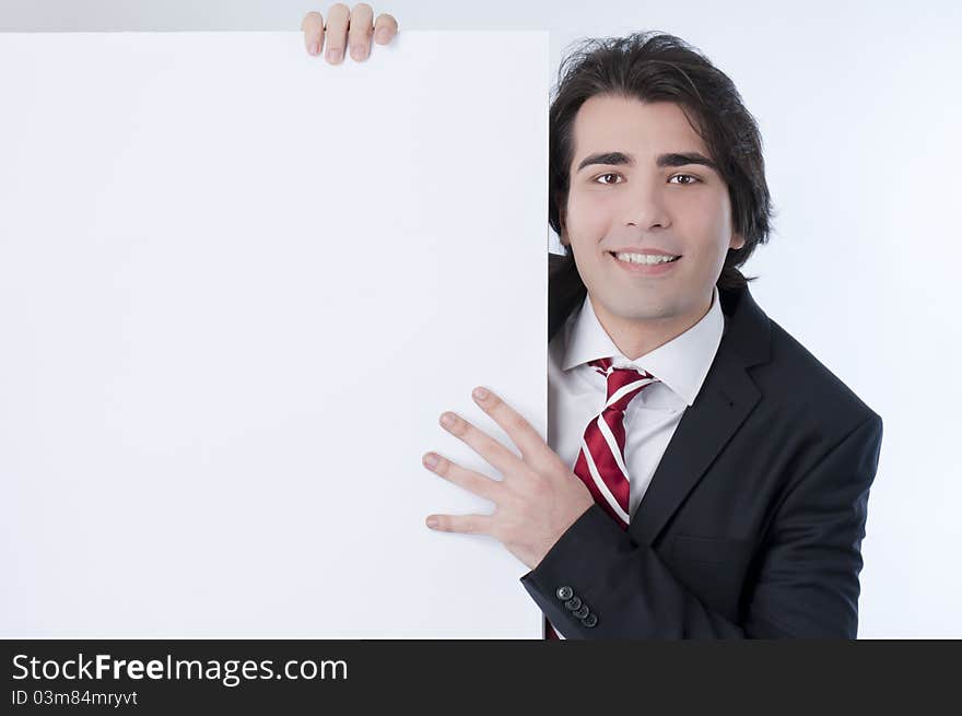 Young man appears from behind a white panel. Young man appears from behind a white panel