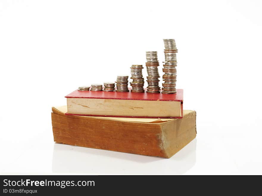 Coins and book on the white background. Coins and book on the white background