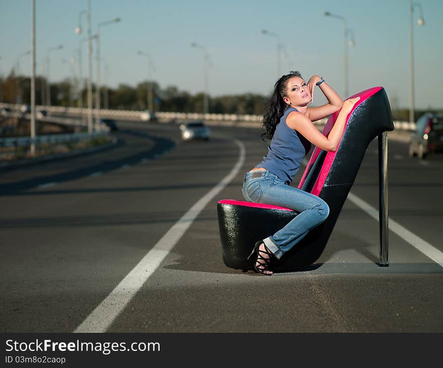 Woman sitting in an armchair on the highway. Woman sitting in an armchair on the highway