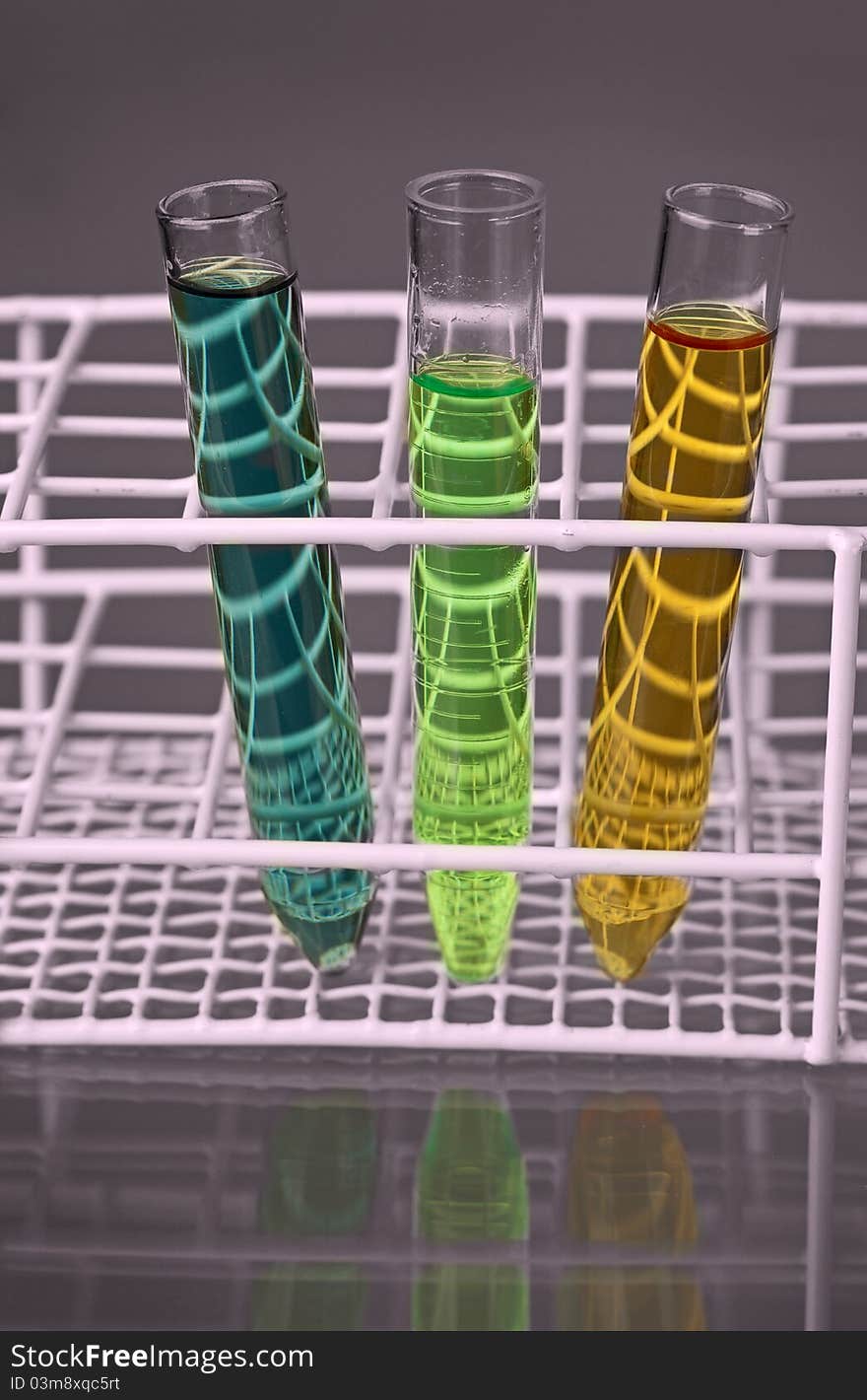 Three test-tubes with fluids in a stand