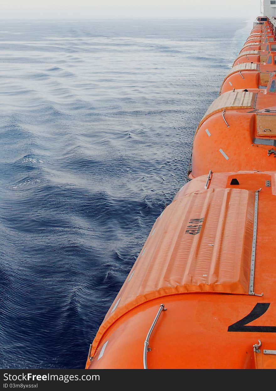 Row of lifeboats on a cruiseship. Row of lifeboats on a cruiseship