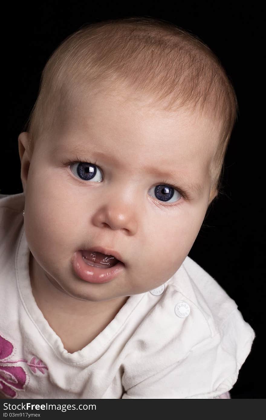 Cute little baby girl portrait closeup on black background