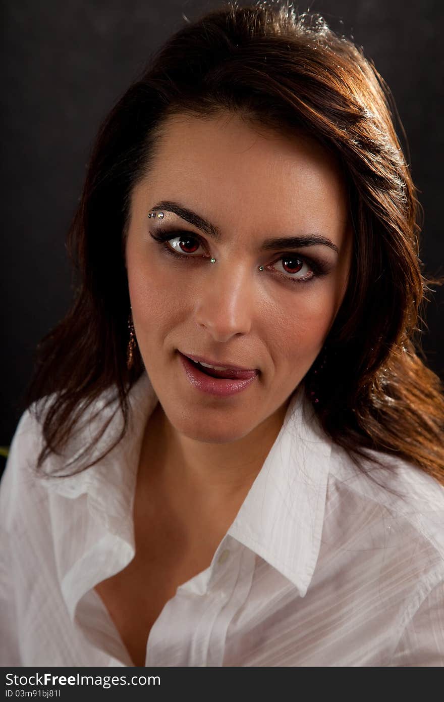 Portrait of an attractive woman in a white blouse on a black background