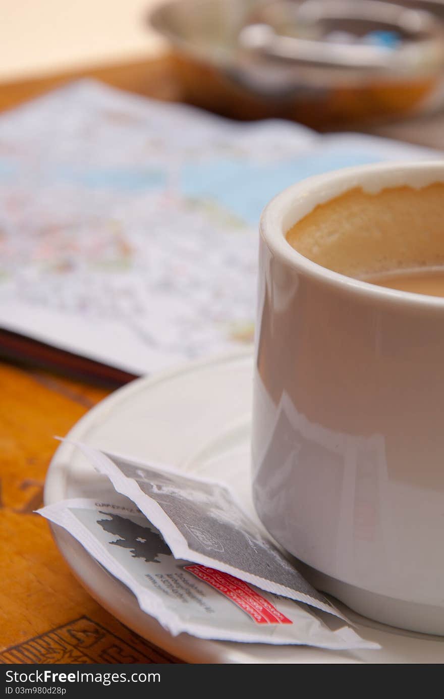 Coffee cup in street cofe. In background city plan.