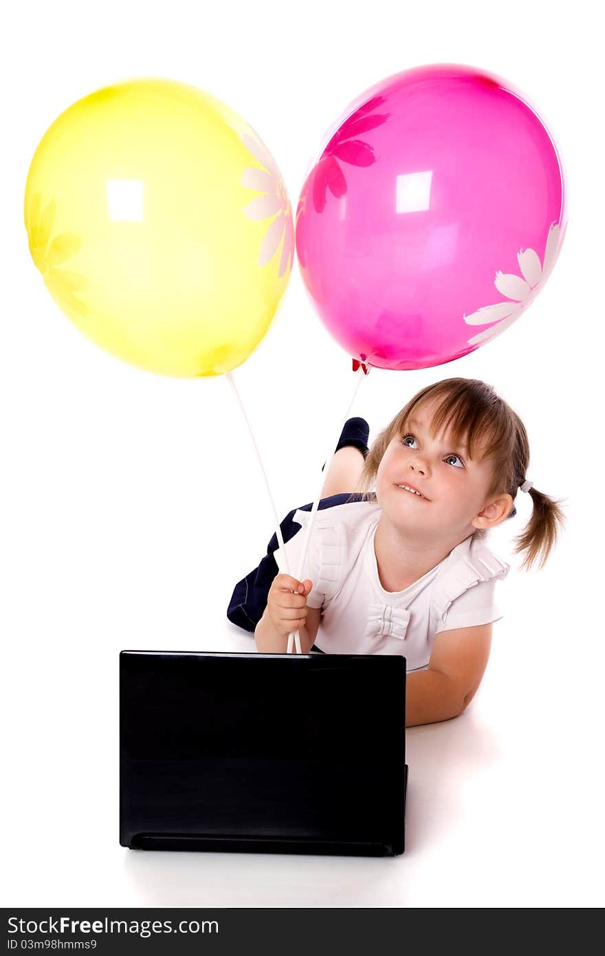The girl with balloons lies in front of the laptop. The girl with balloons lies in front of the laptop