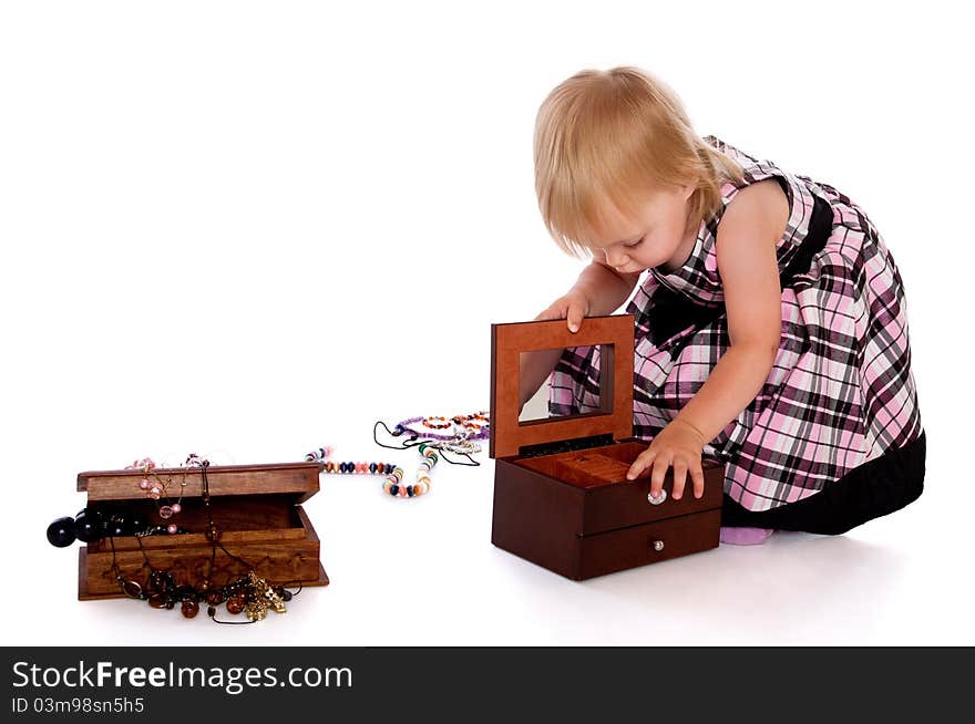 The little girl opens a box with a beads. The little girl opens a box with a beads