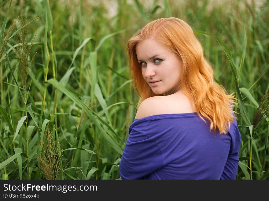 Pretty girl with red haer relaxing outdoor in grass. Pretty girl with red haer relaxing outdoor in grass