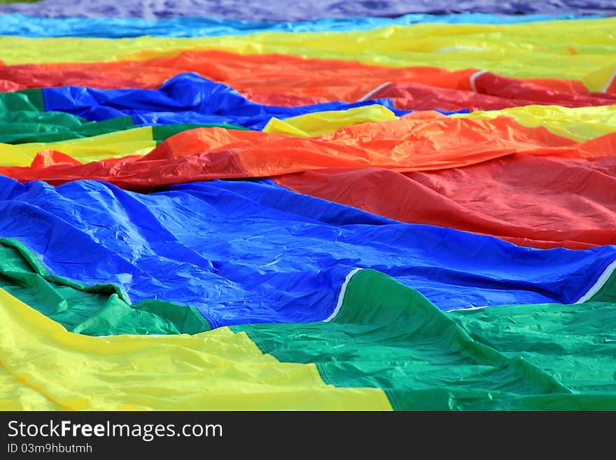 A colorful hot air balloon fabric waiting to be inflated. A colorful hot air balloon fabric waiting to be inflated.