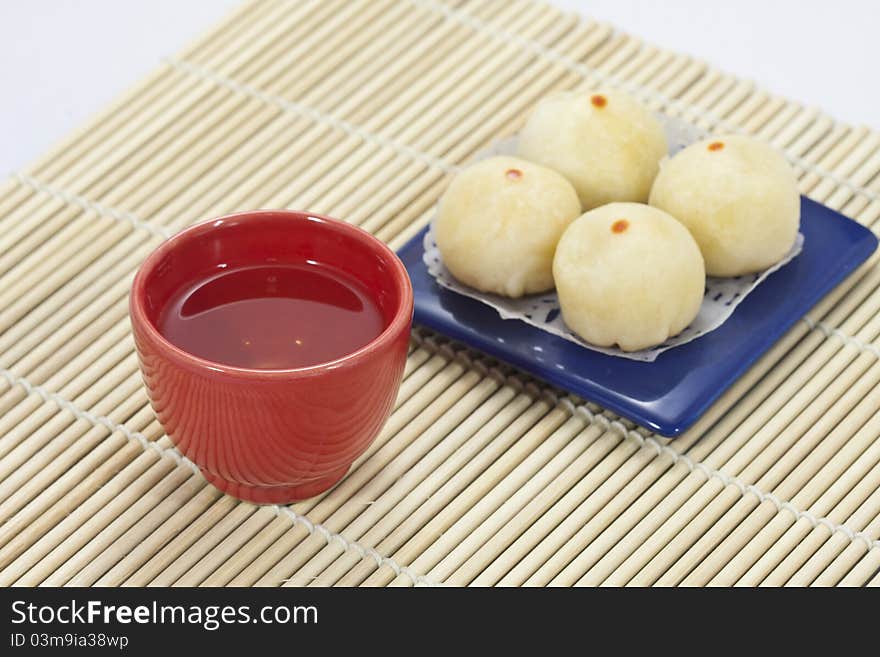 Chinese tea in red cup with chinese cake