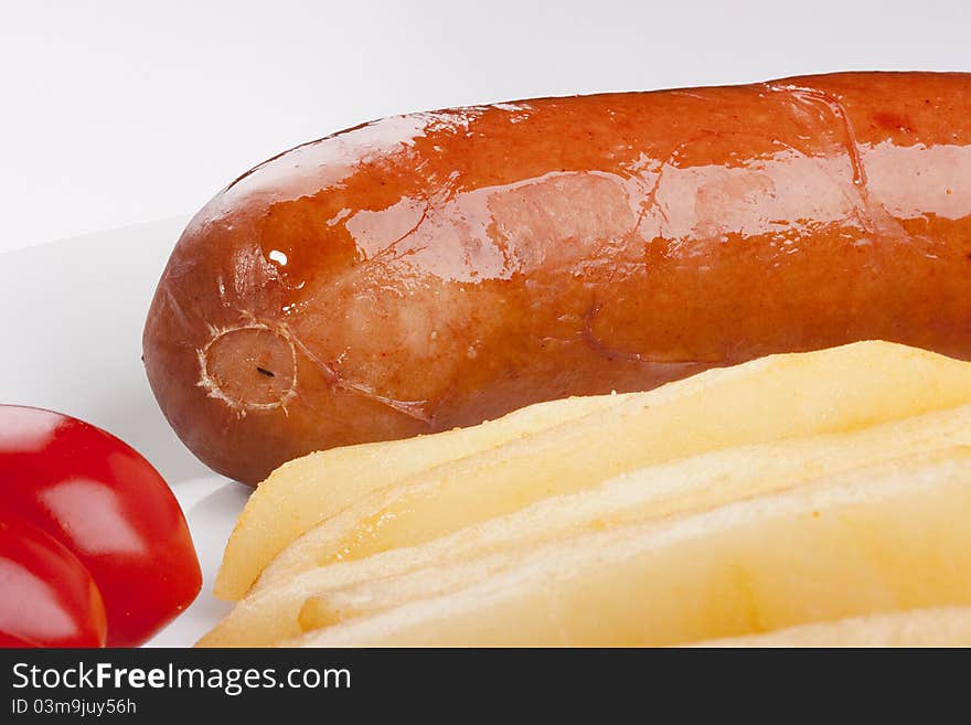 Sausage with a fried potato and tomatoes.