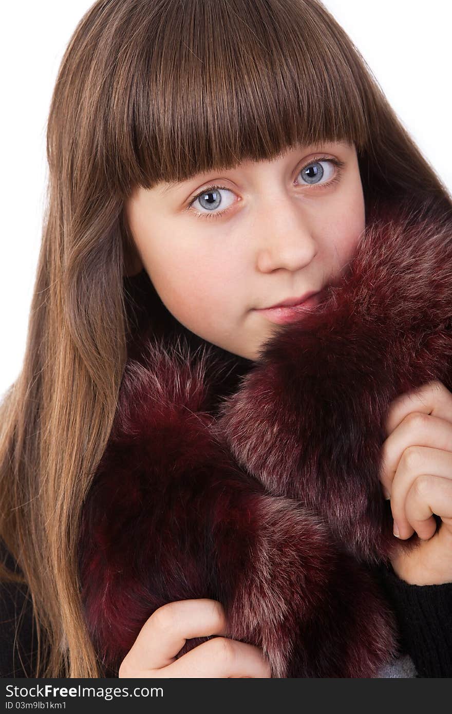 Beautiful young girl in a fur coat isolated on a white background