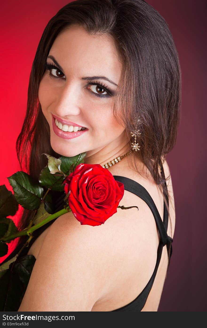 Portrait of young beautiful woman and red rose