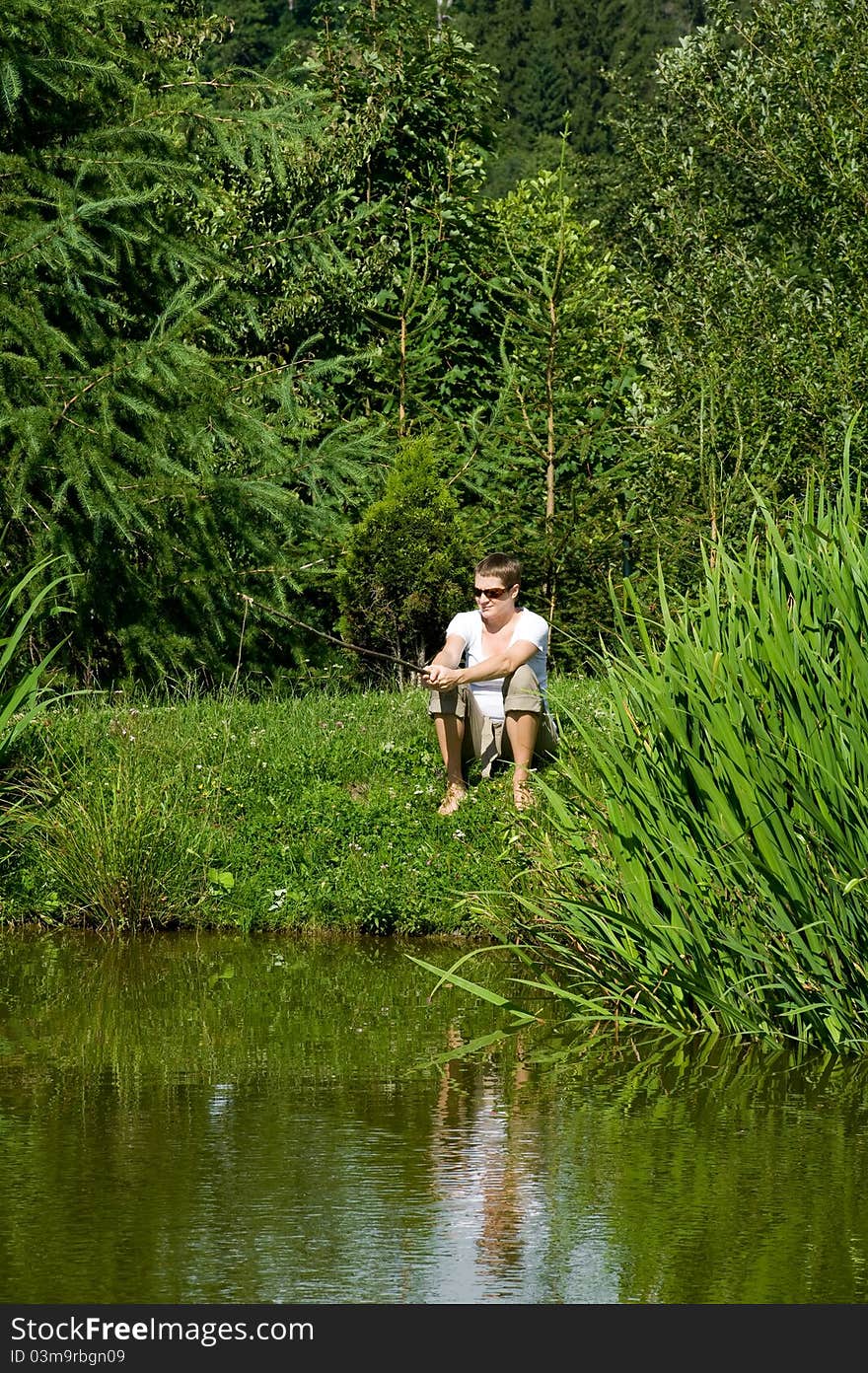 Woman is fishing on the pond