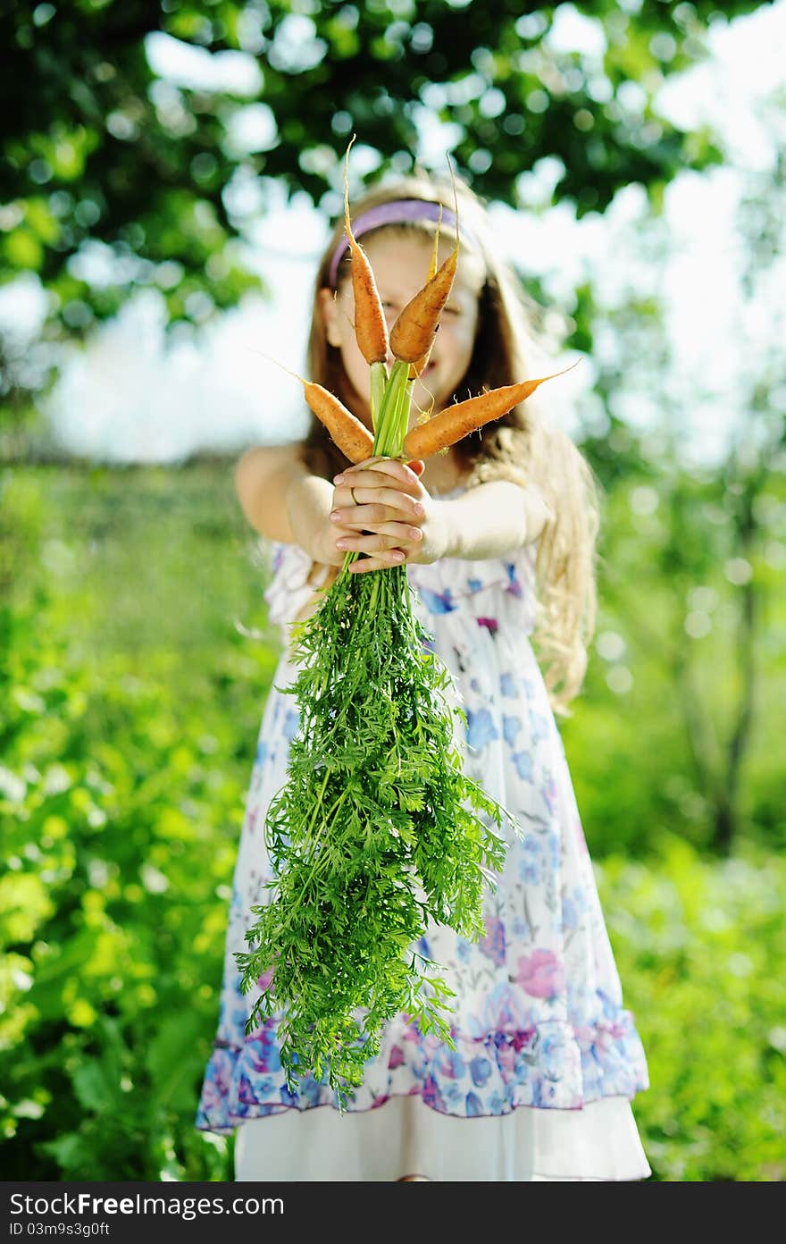 An image of a nice girl with orange carrots. An image of a nice girl with orange carrots