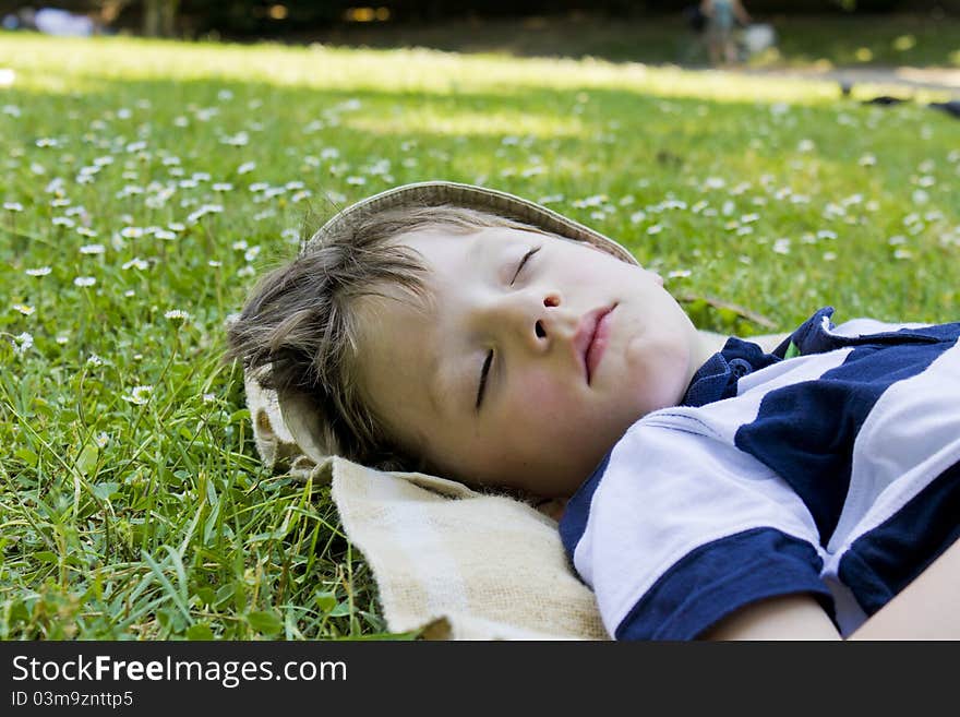 Young boy sleeping in the green grass. Young boy sleeping in the green grass.