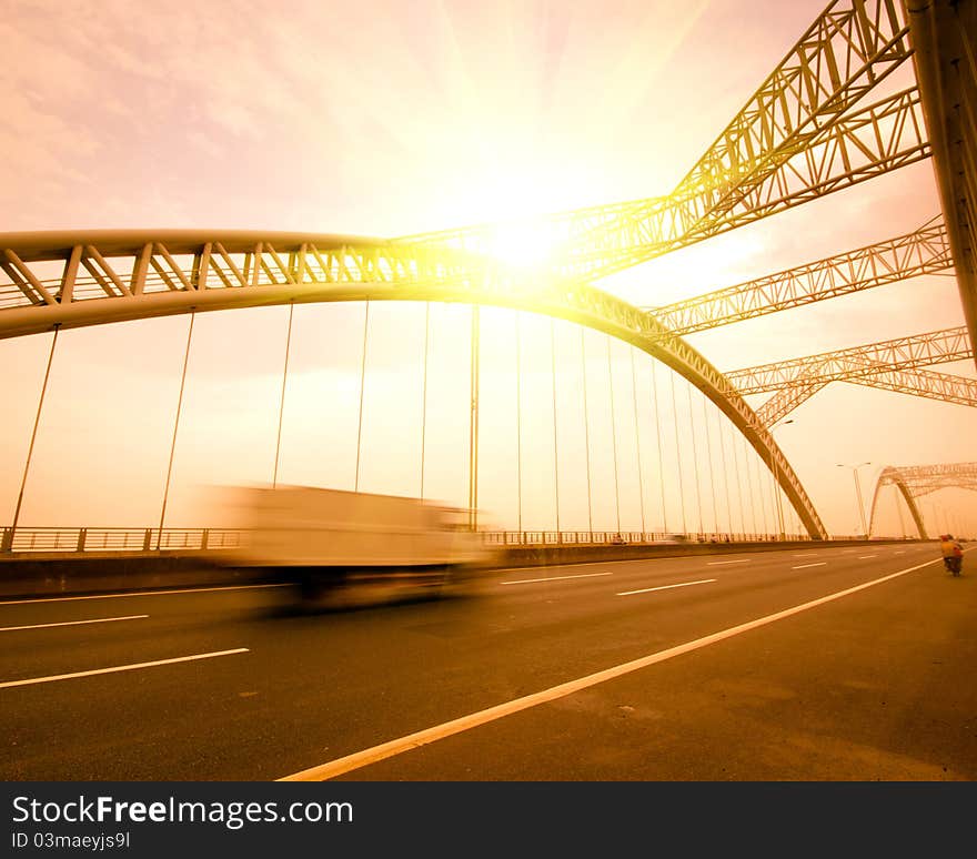 Road through the bridge with blue sky background of a city.