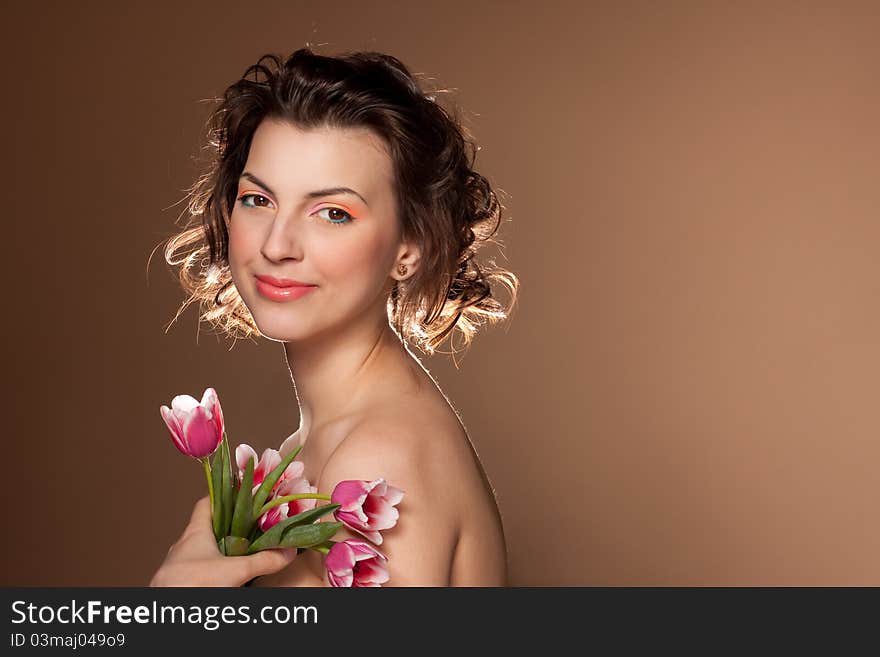 Studio portrait of a beautiful girl with tulips