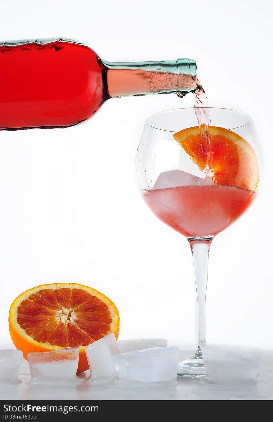 Drink poured into the cup with ice and slice of orange. Drink poured into the cup with ice and slice of orange