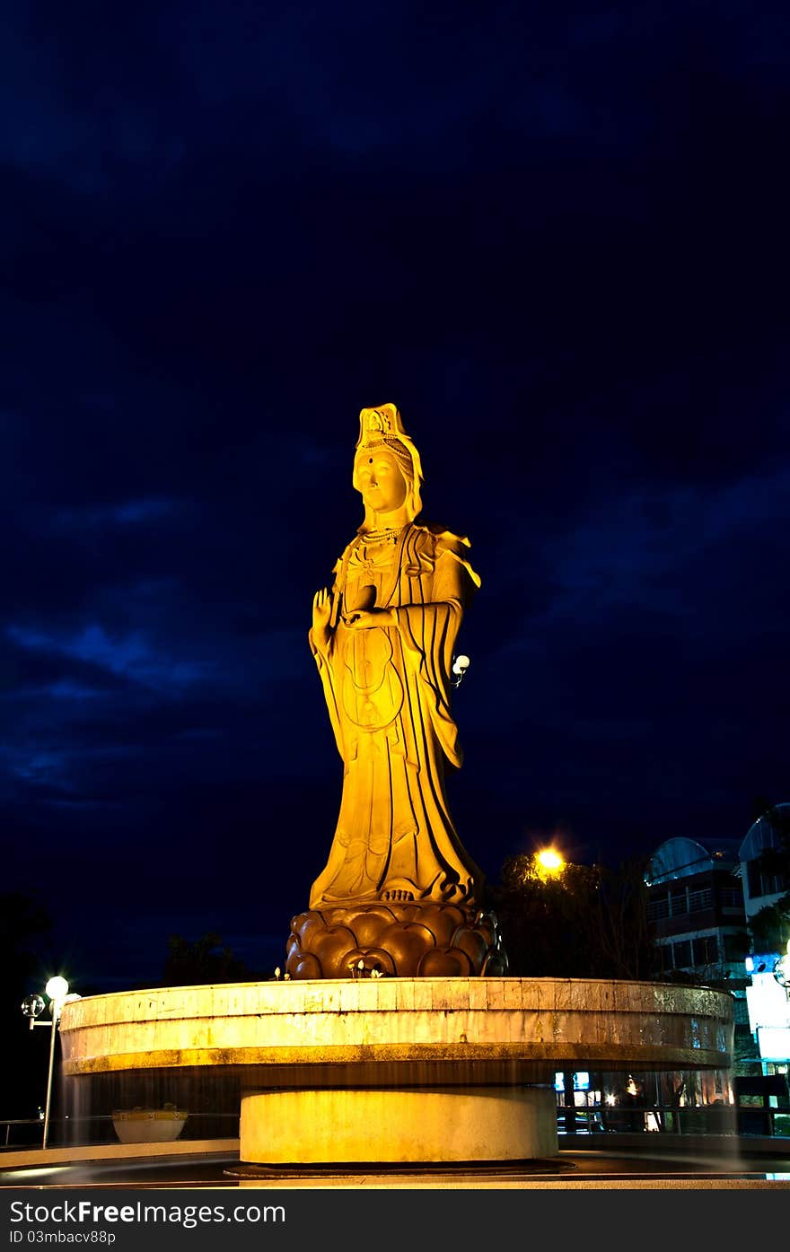 This Guan Yim image is in the center of Khonkaen province, Thailand. It stand on the fountain at the entrance of the park. This picture was captured on a night of cloudy sky. This Guan Yim image is in the center of Khonkaen province, Thailand. It stand on the fountain at the entrance of the park. This picture was captured on a night of cloudy sky.