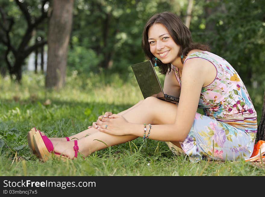 The image of a girl sits on a grass