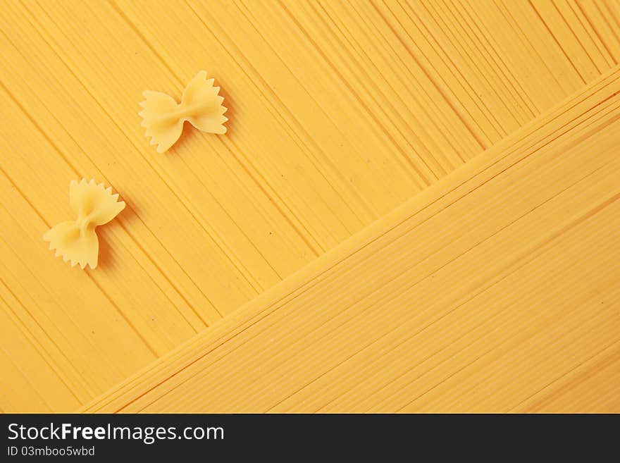 Two farfalle noodles are lying on spaghetti. Two farfalle noodles are lying on spaghetti