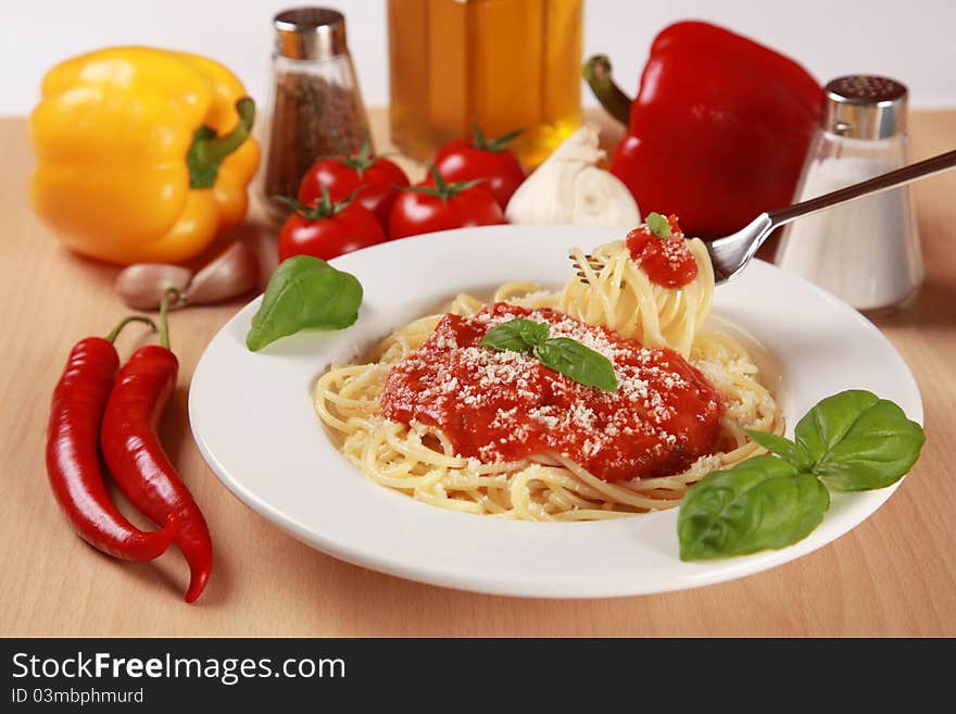 Fresh spaghettis are served with tomato sauce, basil and Parmesan cheese. Fresh spaghettis are served with tomato sauce, basil and Parmesan cheese.