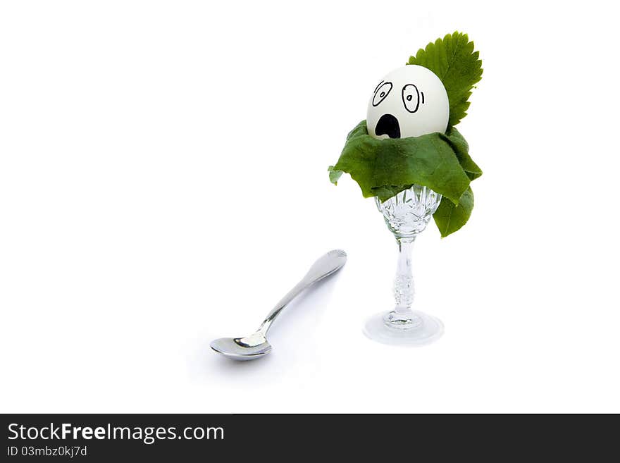 Egg with comic face and a teaspoon on white background