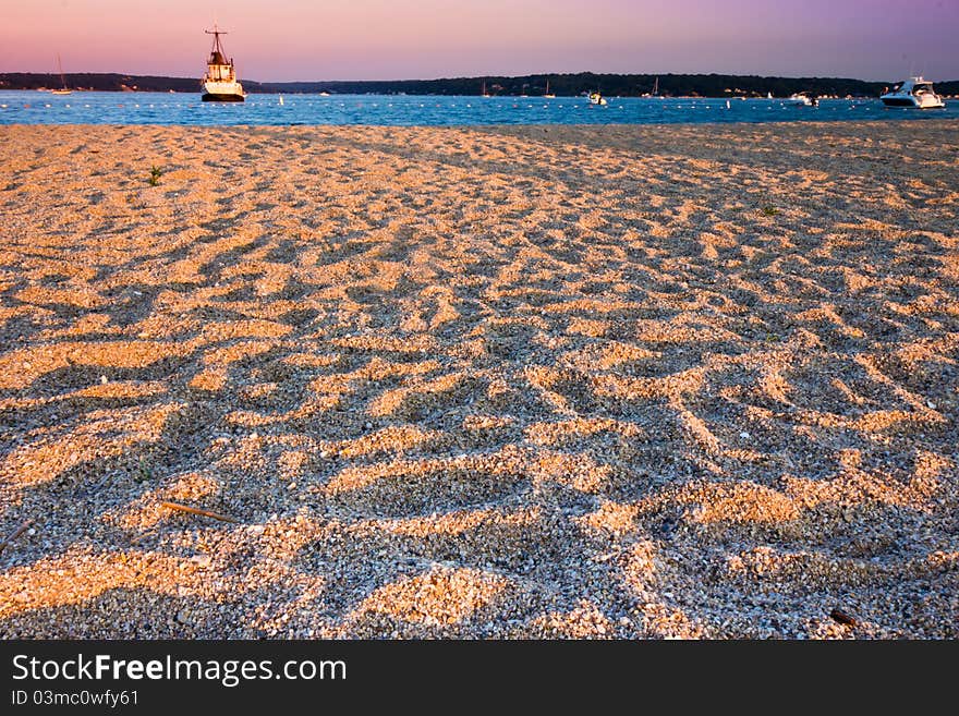 Fishing boat at the end of the day with golden sun falling on the beach