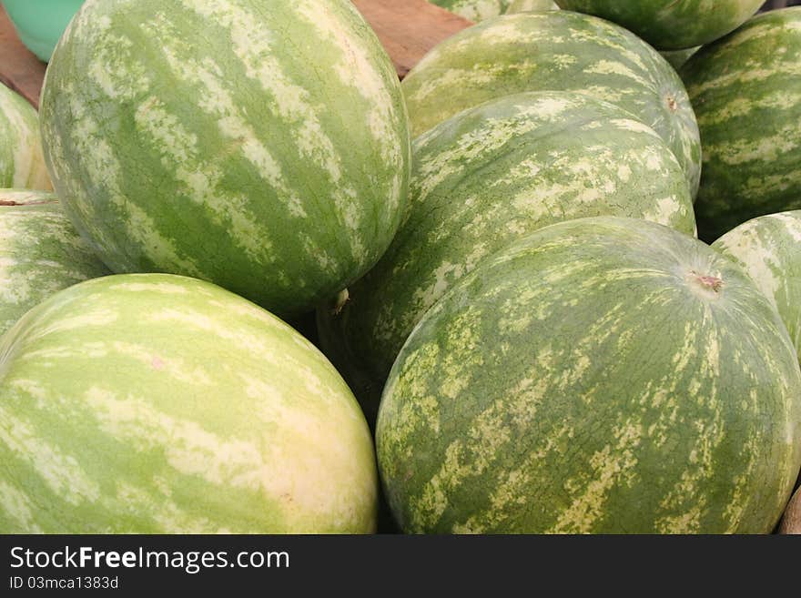 Stack of watermelons at an open air market.