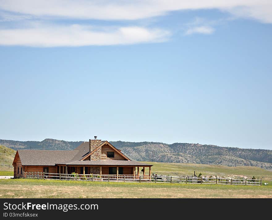 A log cabin in the hills of wyoming, with a log fence. A log cabin in the hills of wyoming, with a log fence.