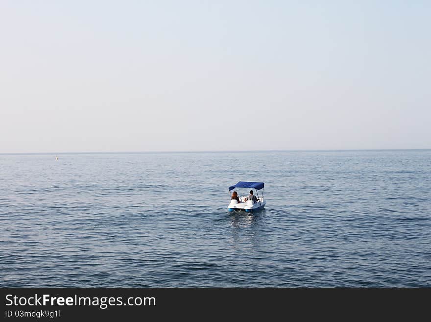 The catamaran with pair people departures in the sea