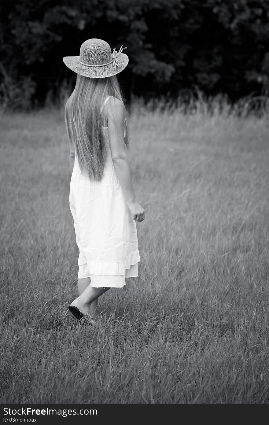 Young beautiful girl walk in straw hat - bw