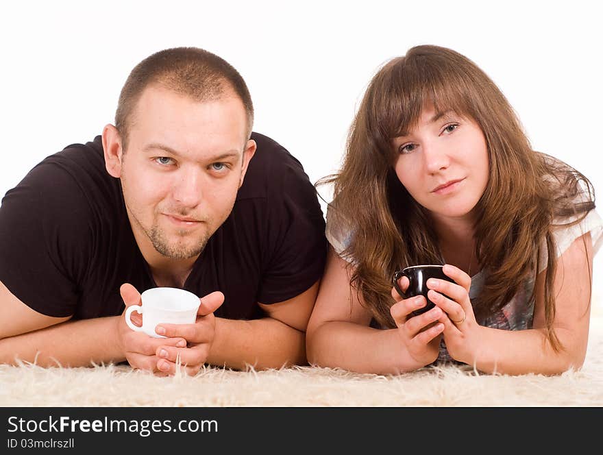 Happy cute couple drinking on a carpet. Happy cute couple drinking on a carpet