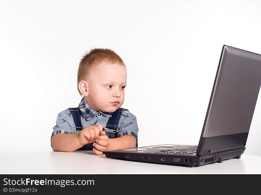 Little boy with a computer on a white. Little boy with a computer on a white