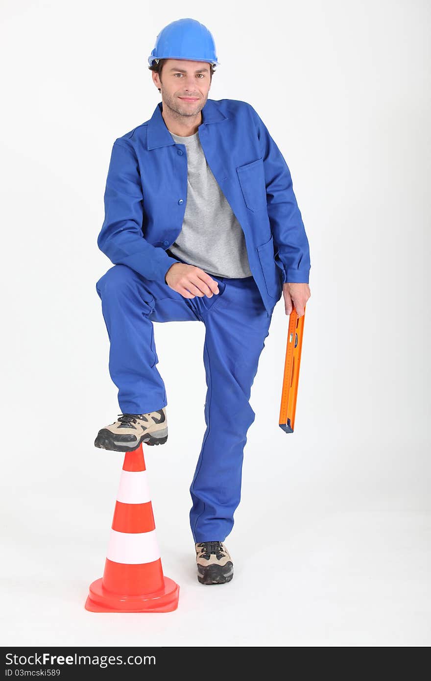 Builder with foot on traffic cone on white background. Builder with foot on traffic cone on white background