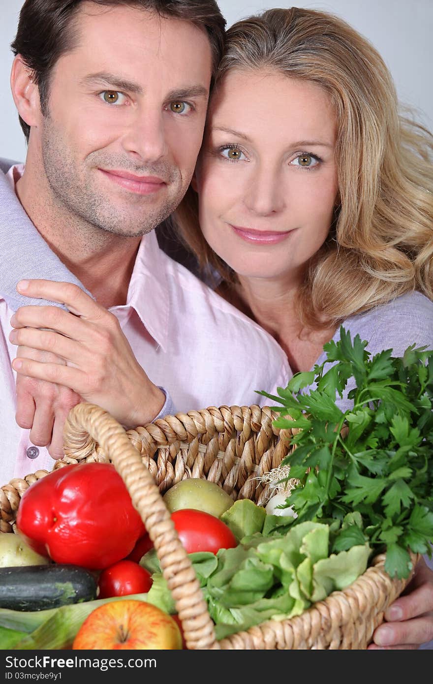 Couple holding basket of vegetables. Couple holding basket of vegetables