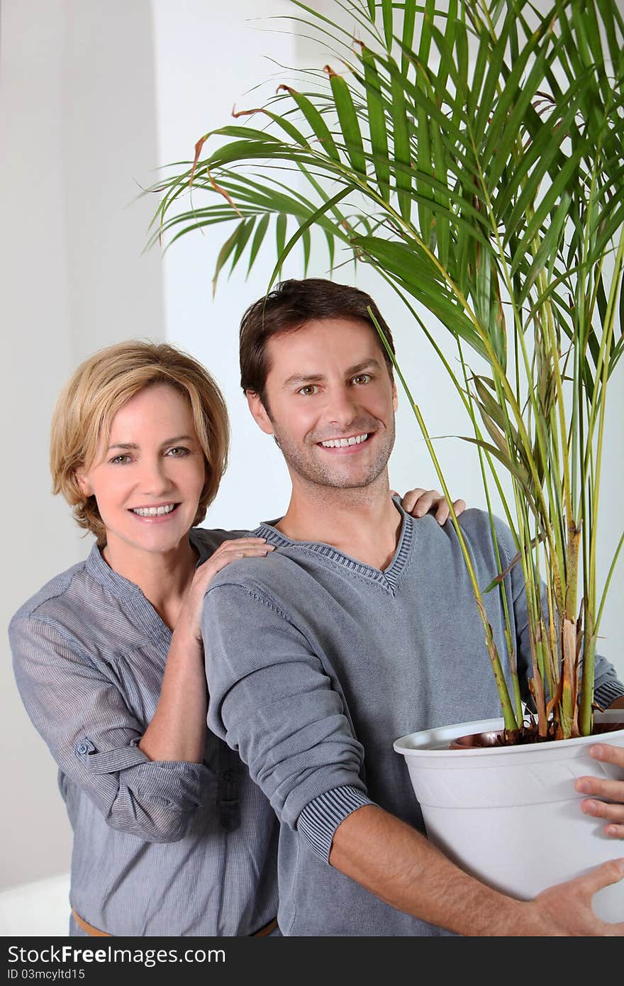 Man carrying a plant and happy woman. Man carrying a plant and happy woman