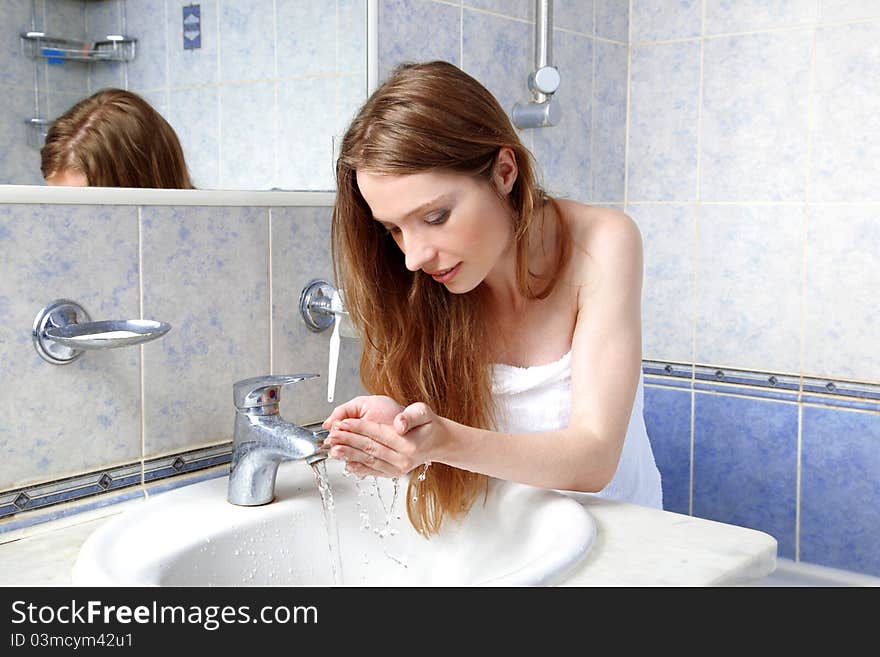 Young woman in bathroom on towel