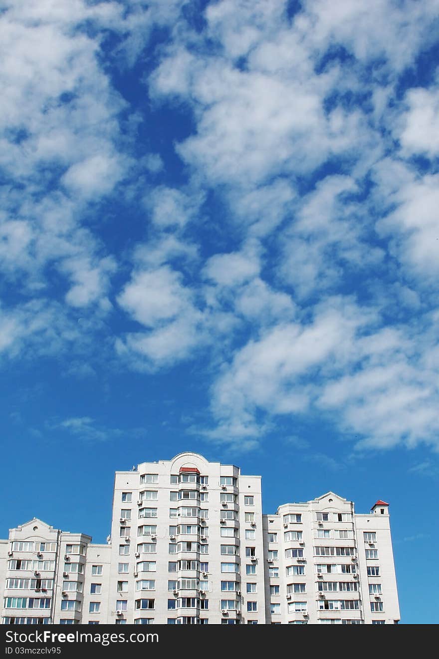 Modern apartment house against the sky with clouds in a city. Modern apartment house against the sky with clouds in a city.