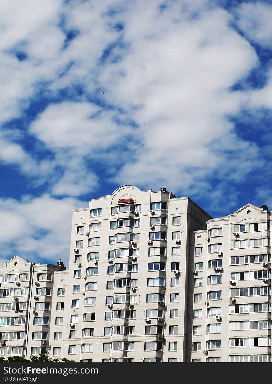 Modern apartment house against the sky with clouds in a city. Modern apartment house against the sky with clouds in a city