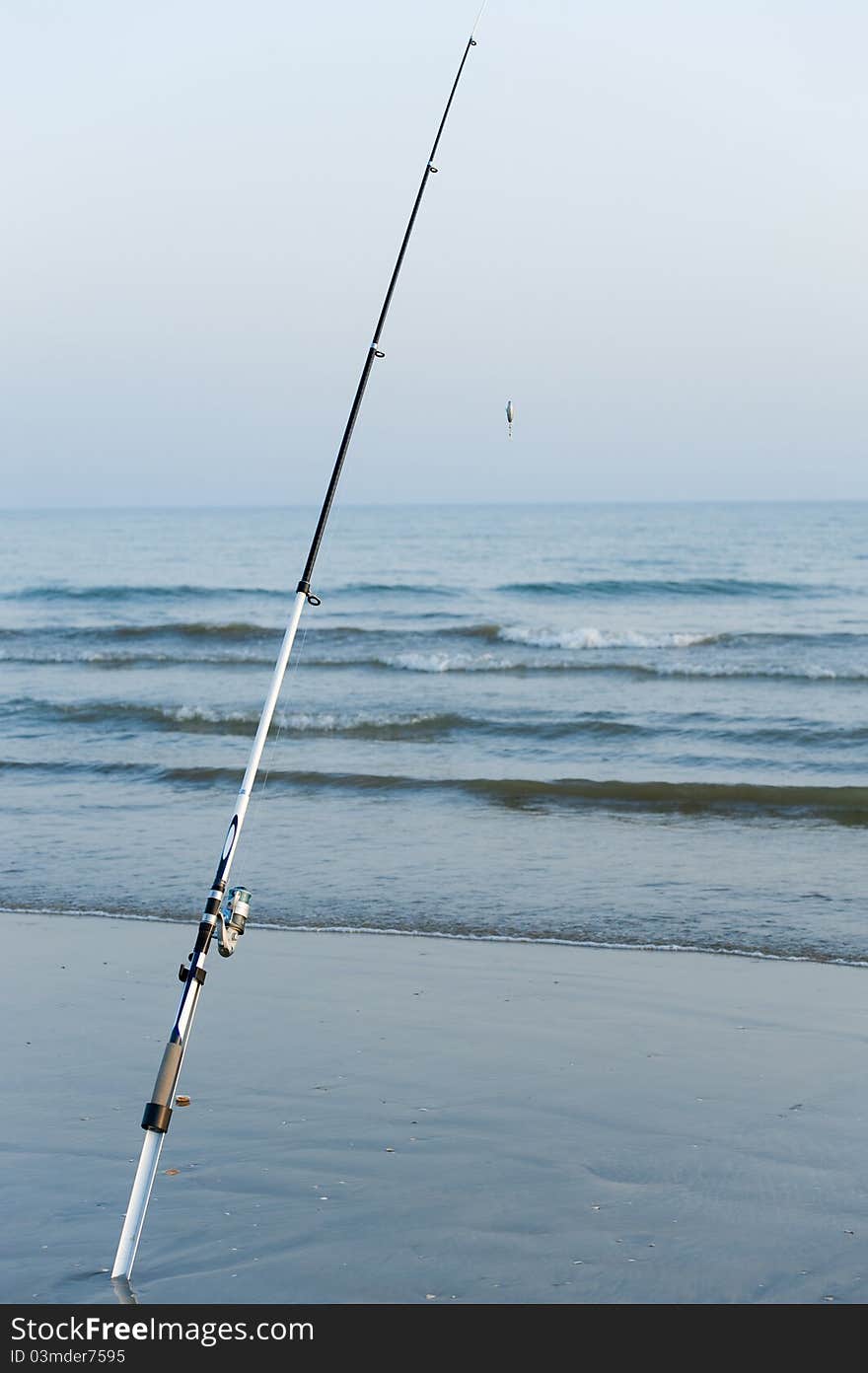 Fishing poles puttet into the sand on the beach. Fishing poles puttet into the sand on the beach